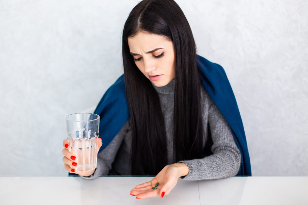 Should I sit up after placing the pills?