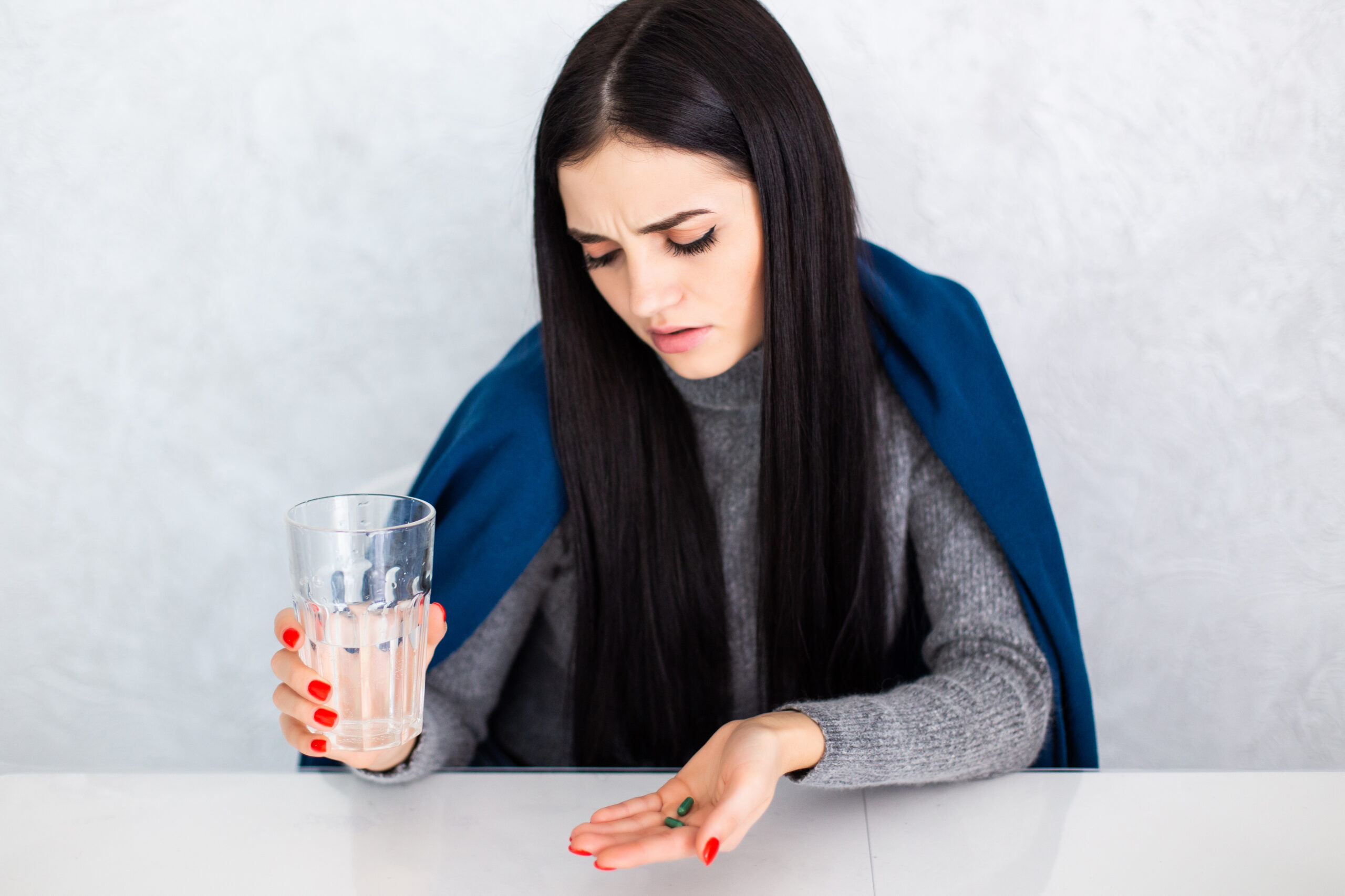 Should I sit up after placing the pills?