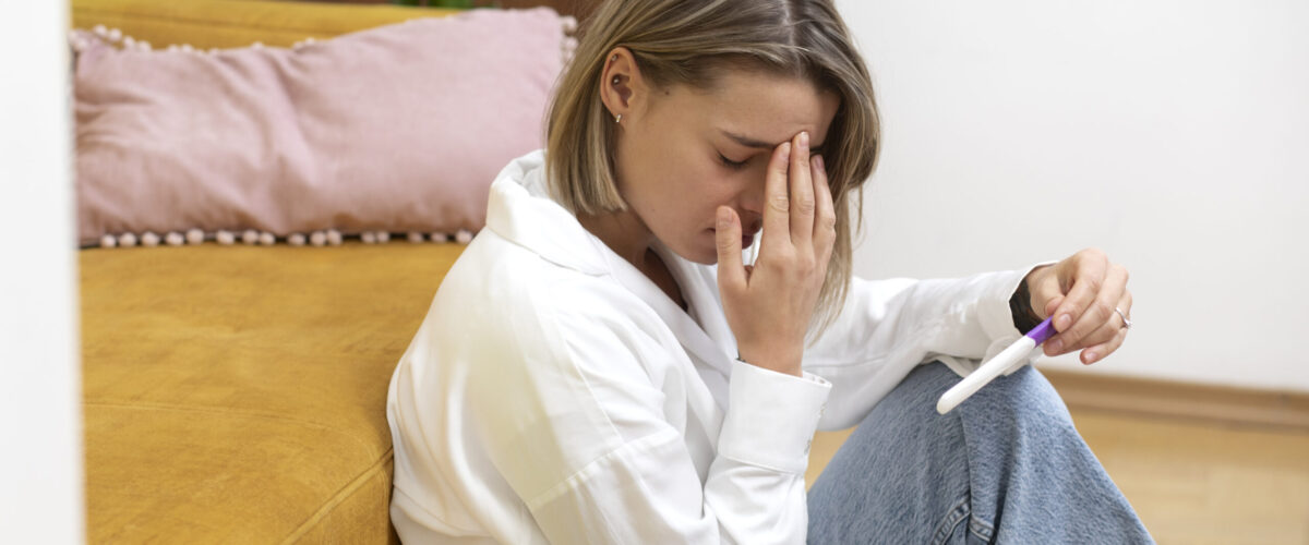 medium-shot-sad-woman-holding-pregnancy-test